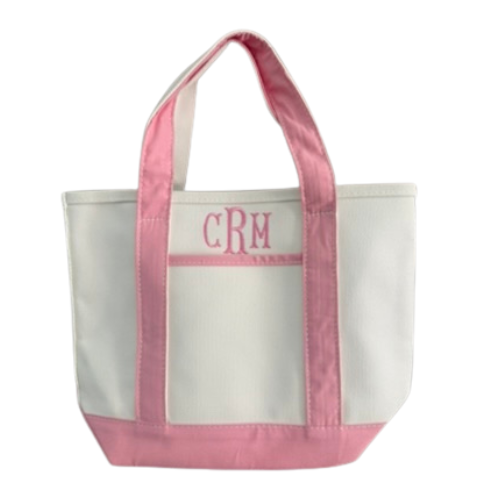 White tote bag with pink handles and trim, featuring initials 'CRM'.