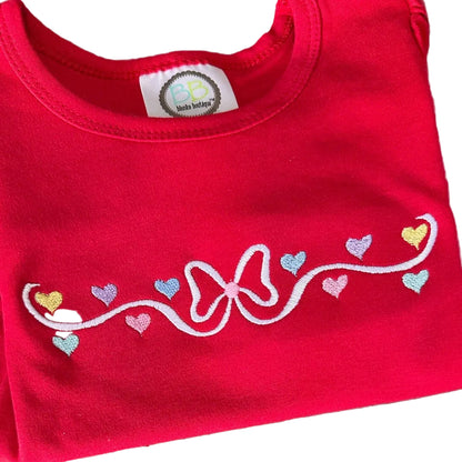 Red shirt with embroidered design of a bow and hearts on a white background