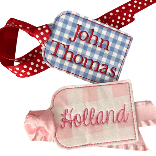Two embroidered name tags on ribbons with 'John Thomas' and 'Holland' text.